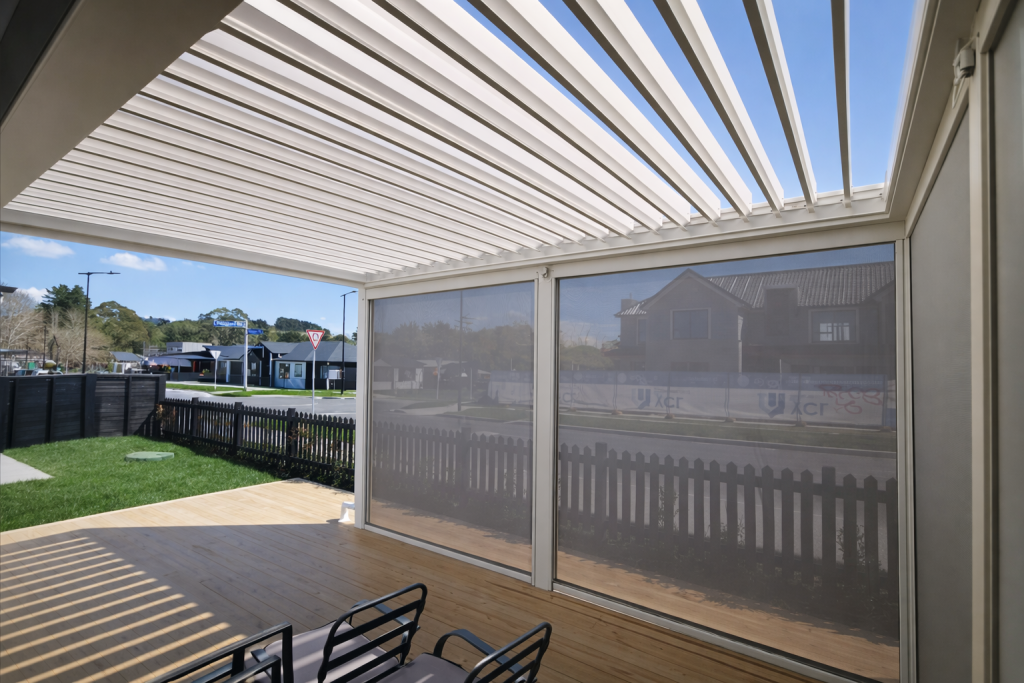 SE Louvre System — adjustable black aluminium louvre roof over a deck with integrated screen blinds